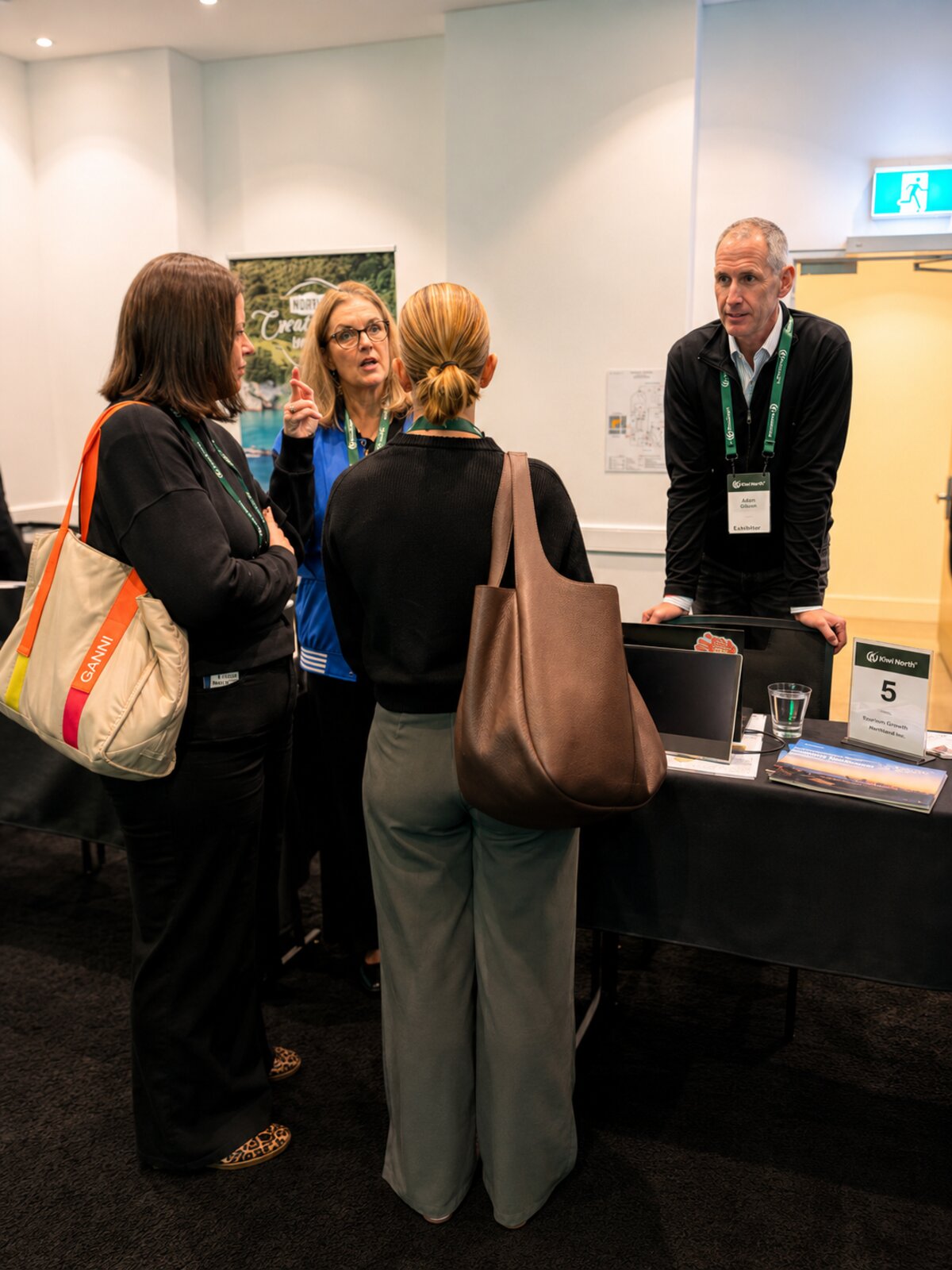 A travel advisor talking with a New Zealand exhibitor